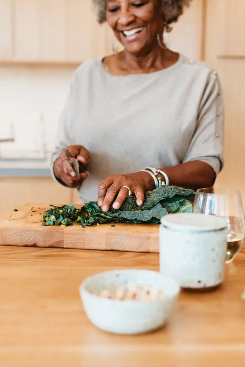Resident chopping kale at Carriage Inn Huntsville in Huntsville, Texas