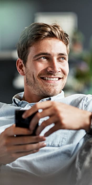 Resident sitting at home with his phone at The Residences at Renaissance in Charlotte, North Carolina