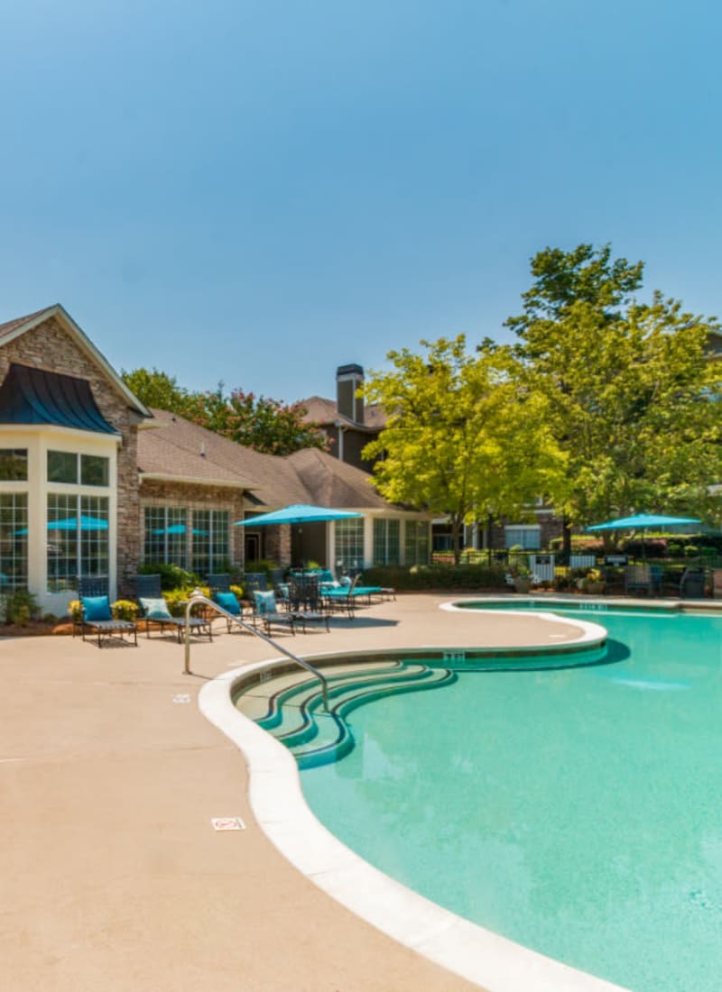 Poolside walk area with lounge chairs and umbrellas at Marquis at Carmel Commons in Charlotte, North Carolina