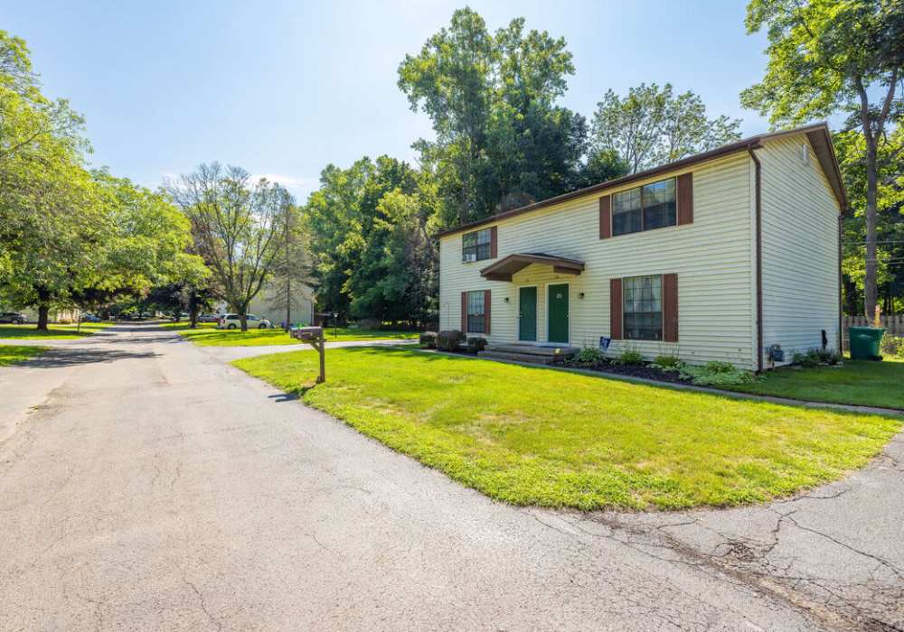 Two-story apartment building with green lawn at Jefferson Manor Townhomes in Fairport, New York