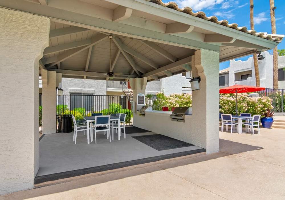 Covered outdoor grill station with seating at Cabrillo Apartments in Scottsdale, Arizona