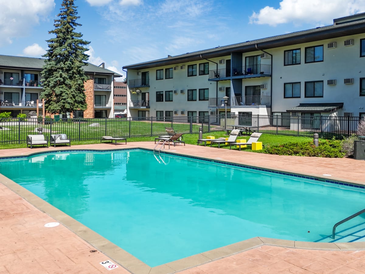 Outdoor swimming pool with pool side loungers at Equinox Apartments in Saint Anthony, Minnesota