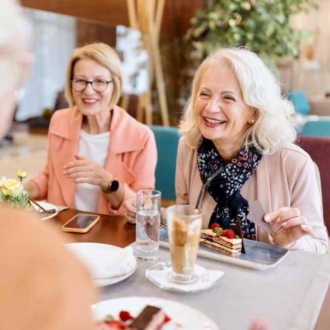 Resident friends sharing a laugh over a meal at their favorite restaurant near Minuet in Las Vegas, Nevada