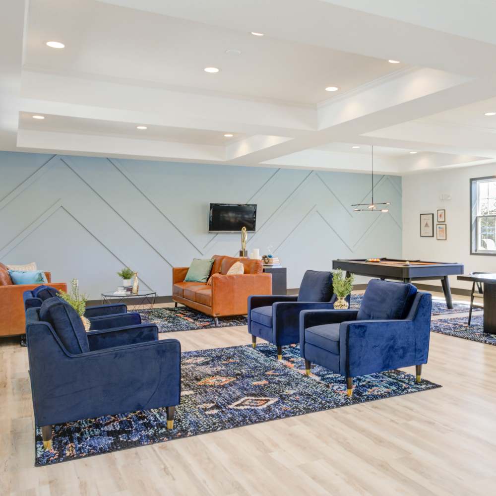 Community clubhouse with seating area and wood-style flooring at Chapel Ridge in Lees Summit, Missouri