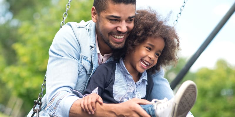 A resident and child on a swing at a park near Bayview Hills in San Diego, California