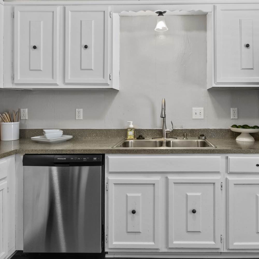 Charming modern kitchen featuring sleek stainless steel appliances and elegant white cabinetry at Pecan Ridge in Vicksburg, Mississippi.