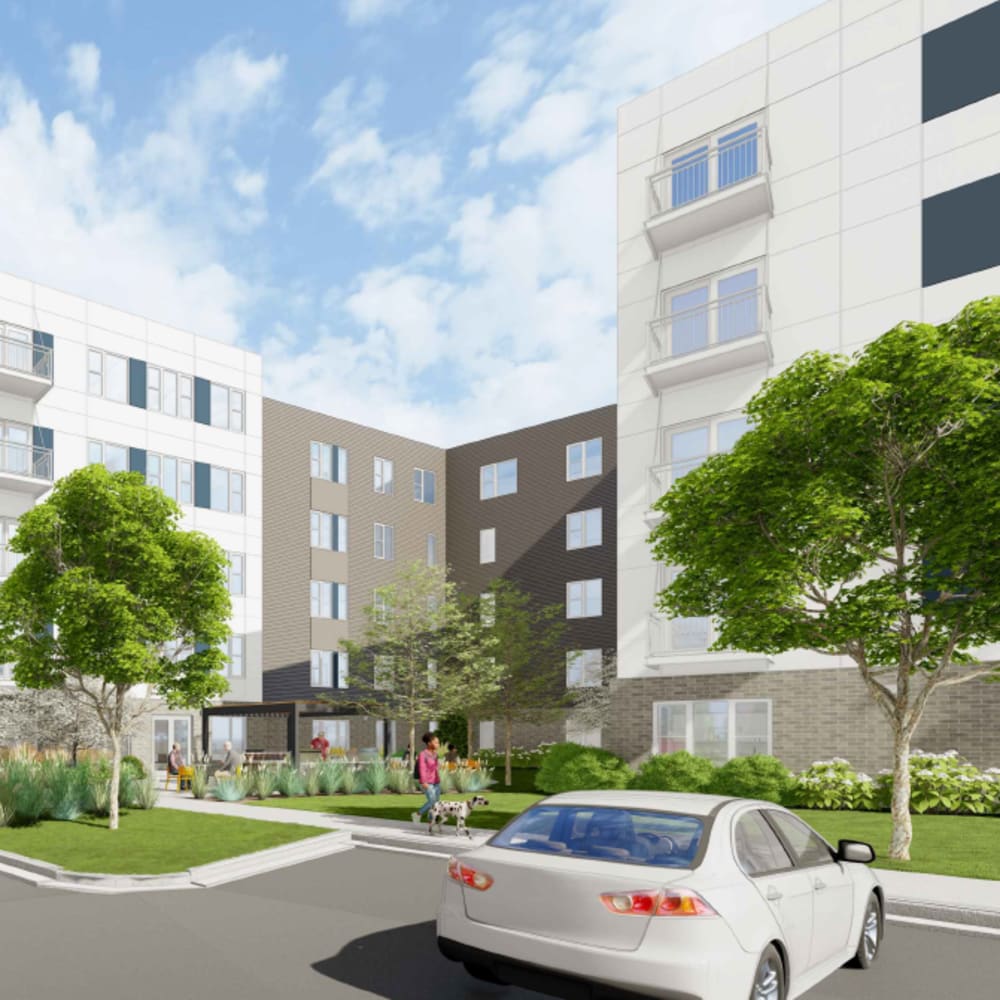 Beautiful exterior view of apartment landscaped courtyard, parked cars, and people walking at The Intersect in Madison, Wisconsin