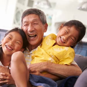 Grandfather hugging his grandchildren at Hale O Meleana in Honolulu, Hawaii