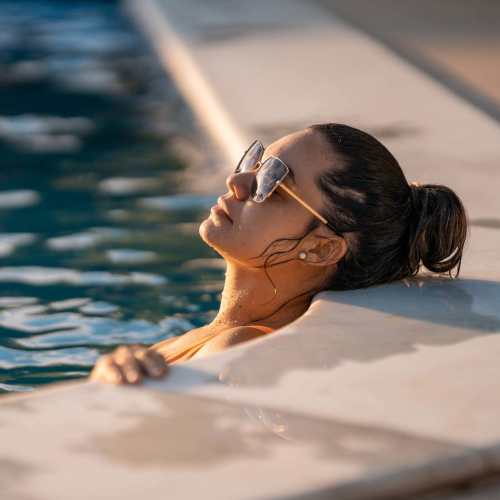 Resident relaxing in the pool at Clear Creek Crossing in Wheat Ridge, Colorado