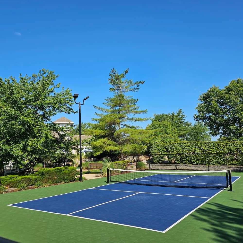 Charming tennis court nestled among lush landscaping at Boulder Springs in Maryland Heights, Missouri.