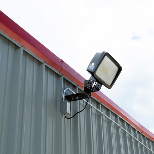 Floodlight mounted on a grey storage unit wall at Red Dot Storage in Denham Springs, Louisiana