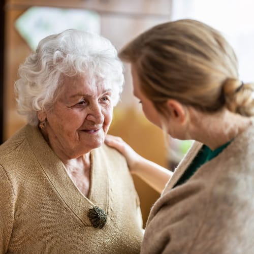 Resident talking with a caretaker at Oxford Springs Tulsa Memory Care in Tulsa, Oklahoma