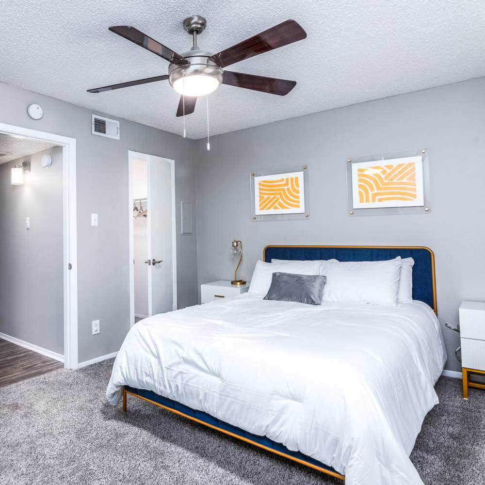 Modern bedroom with ceiling fan and carpet at Sagamore Apartments in Benbrook, Texas