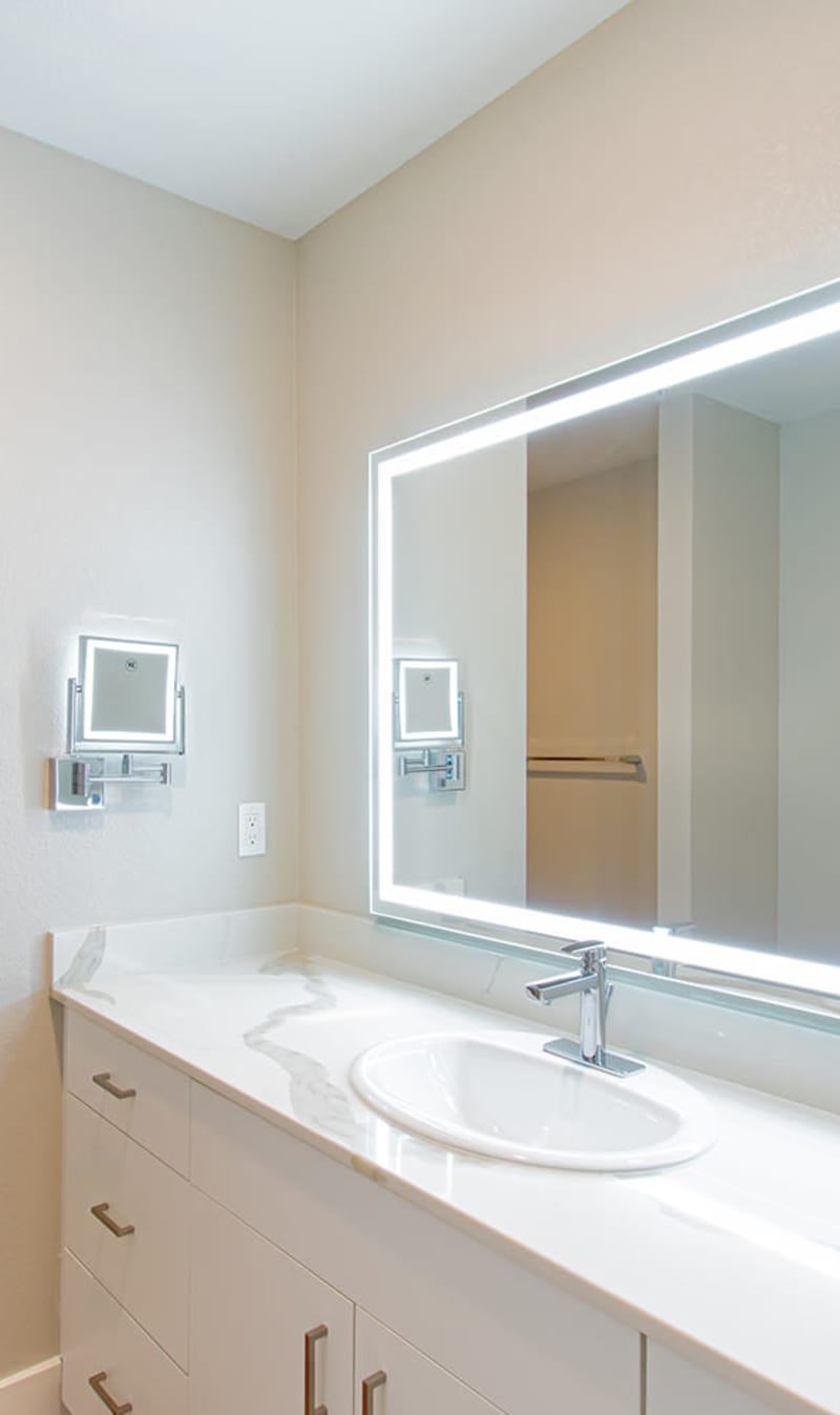 Bathroom with large mirror at Stone Village Apartments in Reno, Nevada