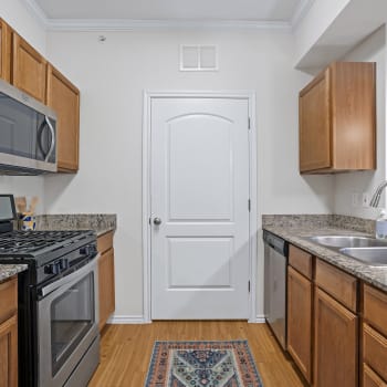 Upgraded kitchen stove and wood flooring in a kitchen at Cypress Creek Joshua Station in Joshua, Texas