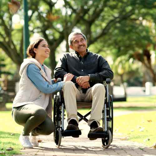 Elderly resident in the wheel chair along with younger resident in a park near Chatham Village in Tustin,California