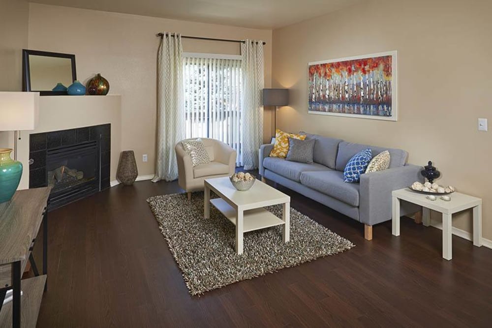 Living room with wood-style flooring at Crossroads at City Center Apartments in Aurora, Colorado