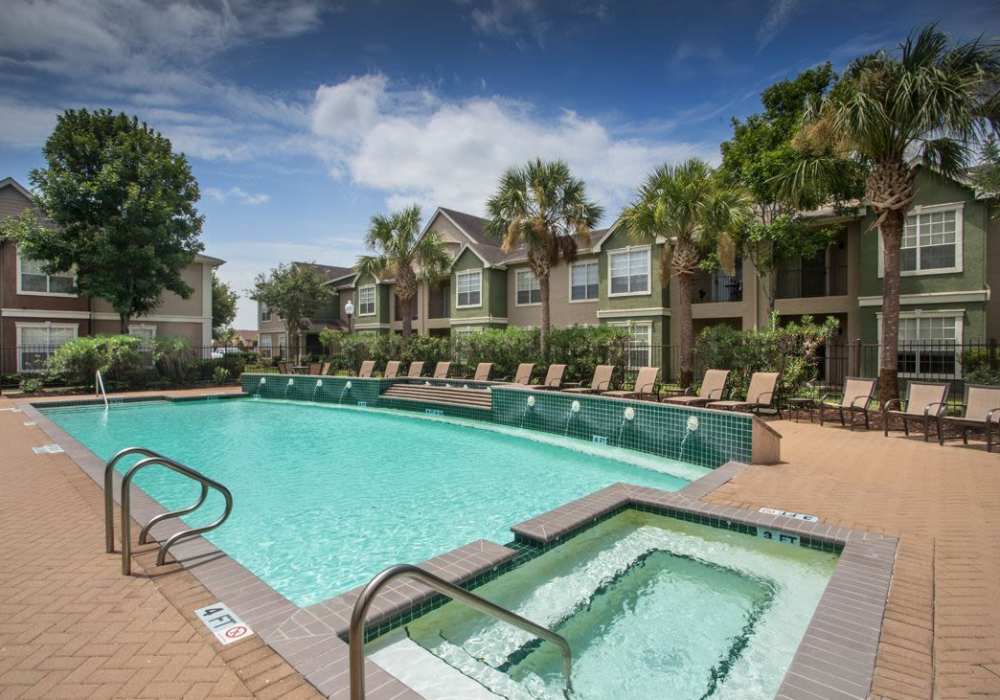 Resort style swimming pool with pool chairs at Reata Apartments in Harlingen, Texas