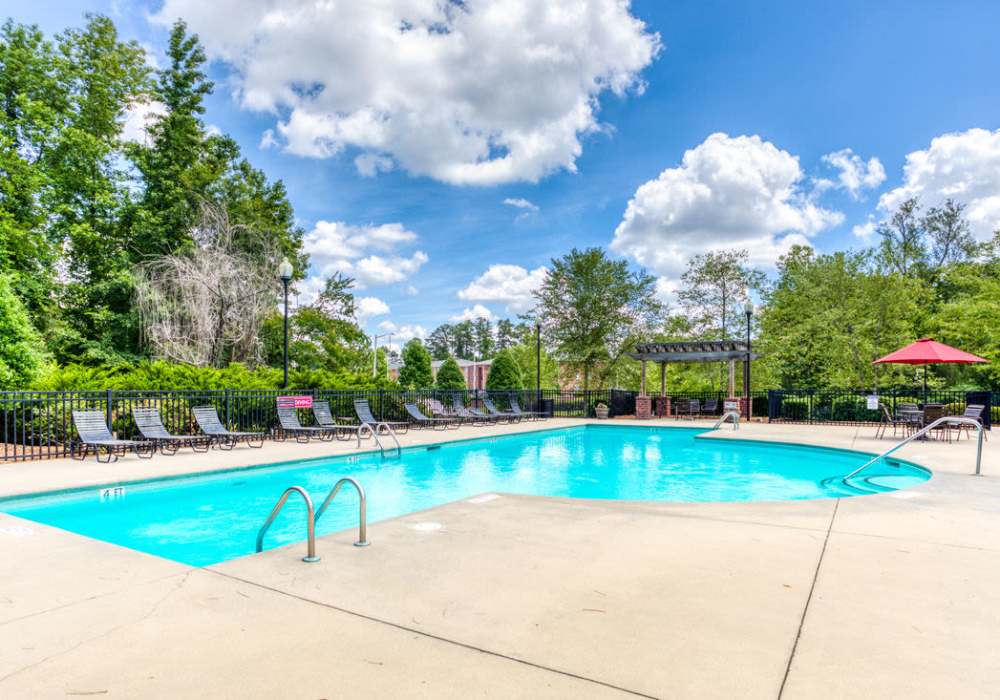 Resort-Inspired pool with large umbrellas to lounge chairs at Eagle Point Village in Fayetteville, North Carolina