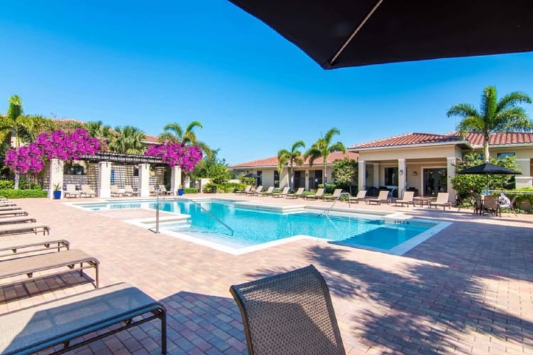 Resort-style swimming pool with plenty of lounge chairs and a bougainvillea-covered pagoda at The Residences at Lakehouse in Miami Lakes, Florida