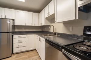 Kitchen with white cabinetry and appliances at The Village at SoTa in Tacoma, Washington