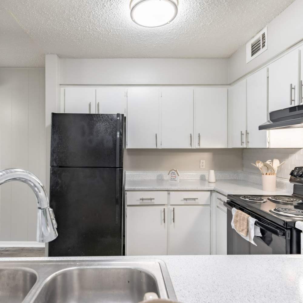 Combined view of kitchen and living room at Arbor Park Apartments in Hurst, Texas