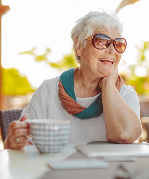 A happy resident holding a cup of coffee at Grand Villa Senior Living in Clearwater, Florida