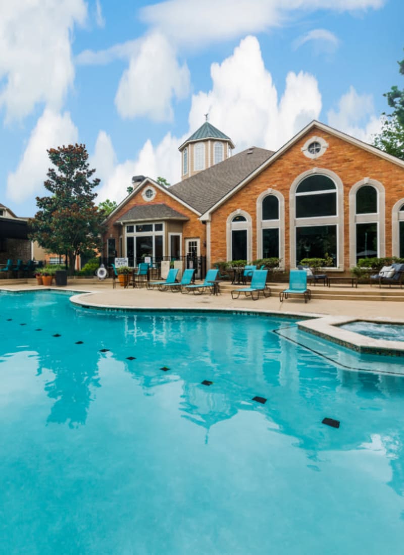 Sparkling pool with hot tub and turquoise lounge chairs Marquis at Kingwood in Kingwood, Texas