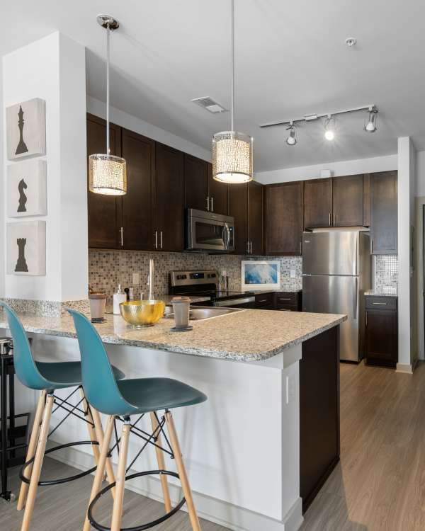 Upscale kitchen with stainless-steel appliances and pendant lighting in an apartment home at Duet in Nashville, Tennessee