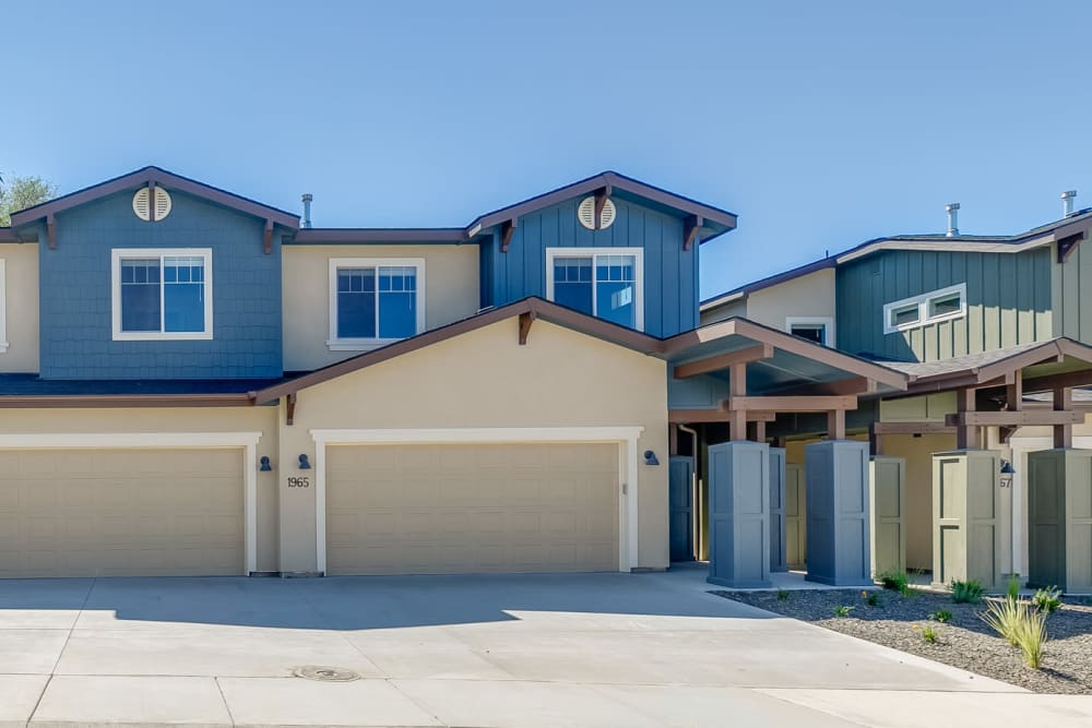 Exterior of townhomes with attached garages and wide driveways at Olympus at Ten Mile in Meridian, Idaho