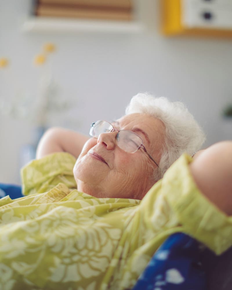 Resident relaxing on a couch in their apartment at Apple Creek Place in Appleton, Wisconsin