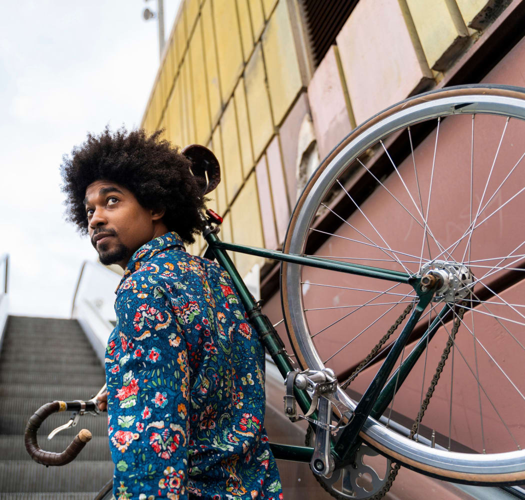 A young man carrying a bike up a flight of stairs near BestBox Storage in Saint Louis, Missouri