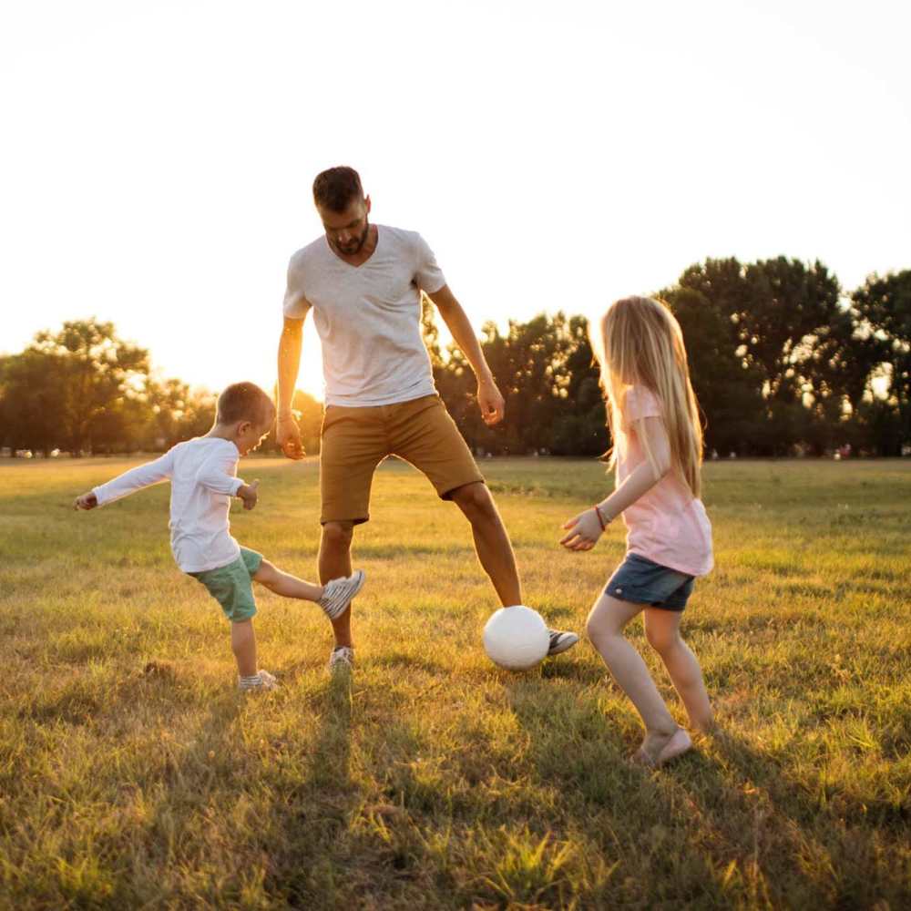 Resident family playing football in park near Spartan Ridge in Eightmile, Alabama