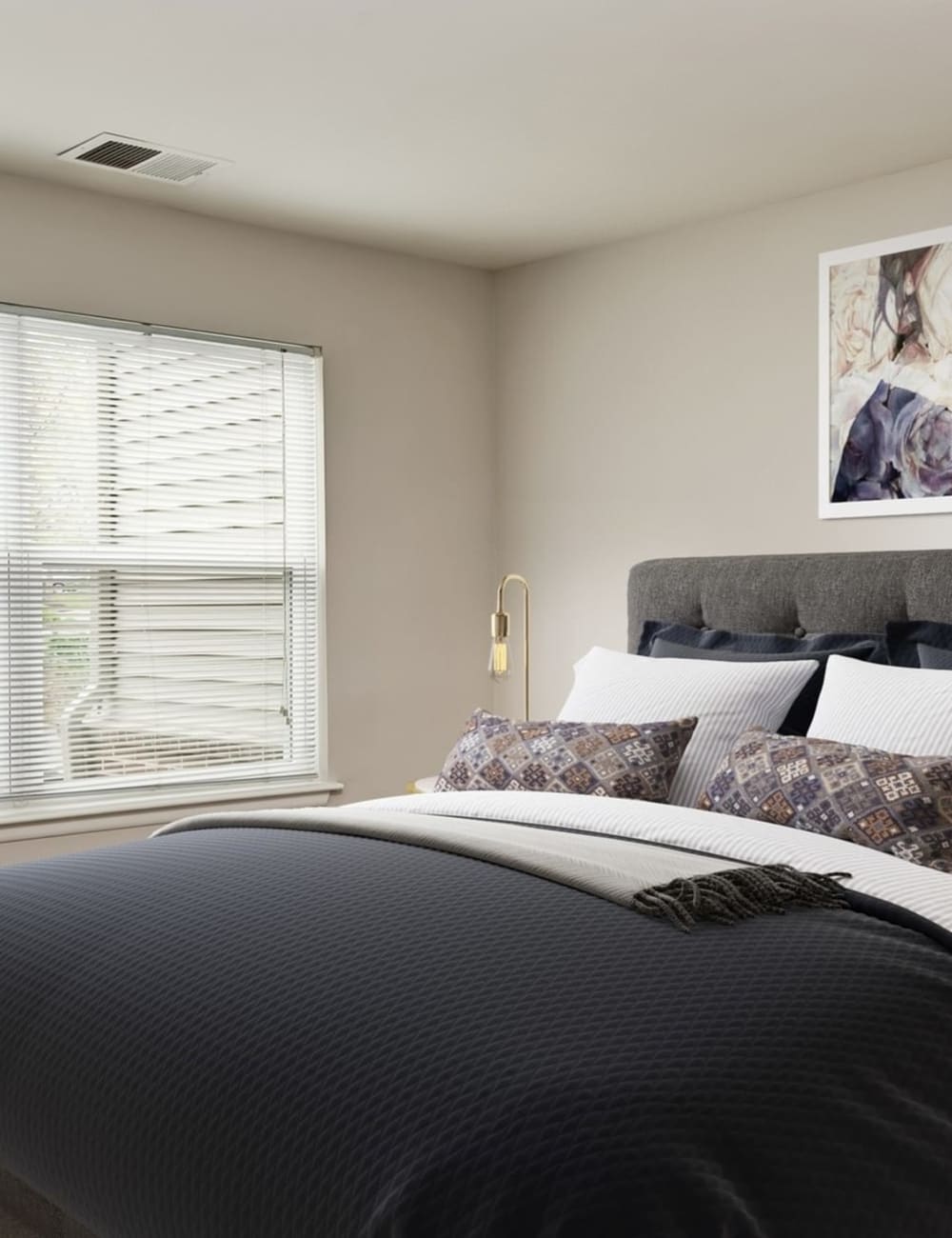 A large bed in a model apartment bedroom at Hunt Club in Gaithersburg, Maryland