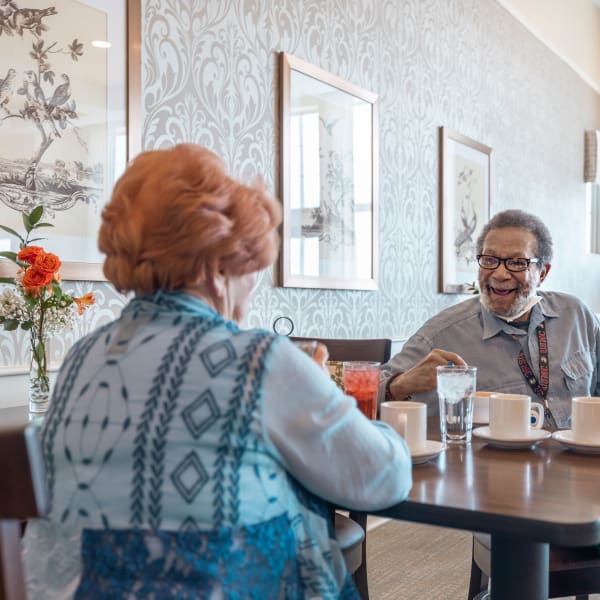 Residents having a conversation over lunch at The Madison Senior Living in Kansas City, Missouri