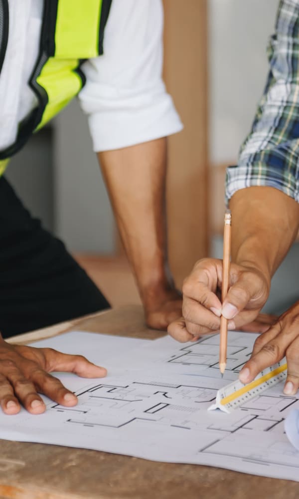 Employees looking over blueprints at TM Real Estate Group in Coconut Grove, Florida