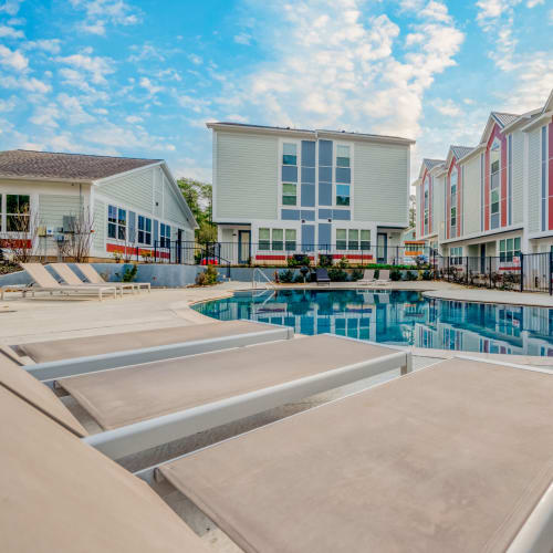 Lounge seating by the swimming pool at Huntsville Village Apartments in Huntsville, Texas