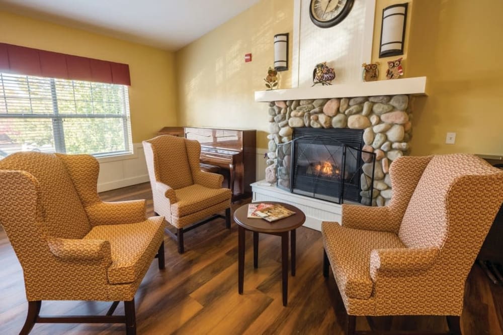 Comfy armchair seating with fireplace at at Lakeland Senior Living in Eagle Point, Oregon. 