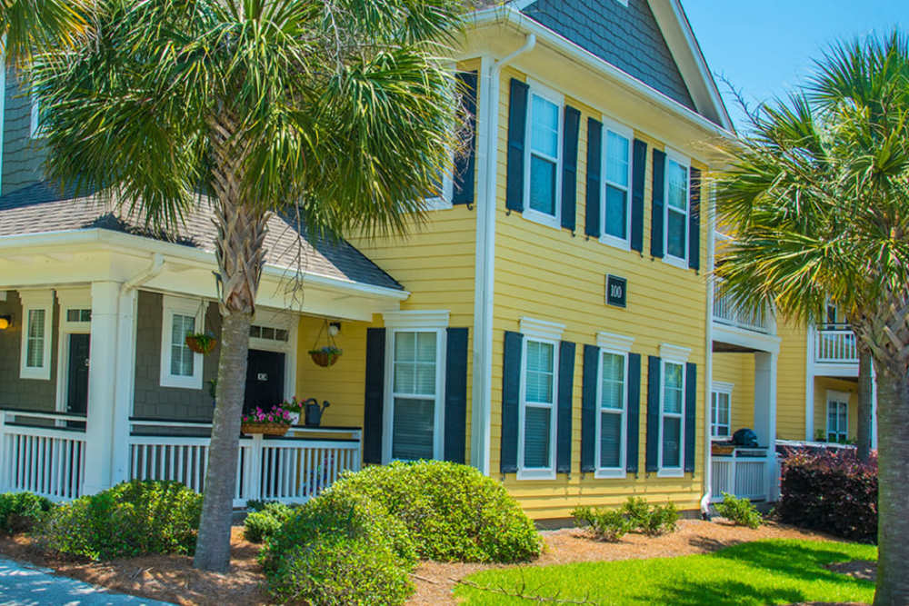 Exteriror apartment with front porch, and palm trees , parking bicycles at Magnolia Downs in Charleston, South Carolina
