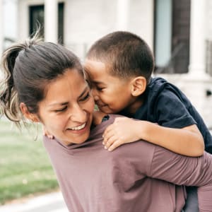 Resident and son smiling outside of their apartment at Ridgeway Apartments in Midlothian, Texas