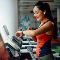 Woman exercising on treadmill in fitness center at Terramonte Apartment Homes in Pomona, California