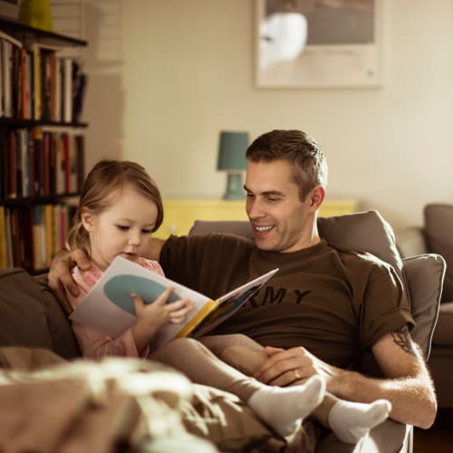 A father and his daughter reading a book in a home at Madigan in Joint Base Lewis McChord, Washington