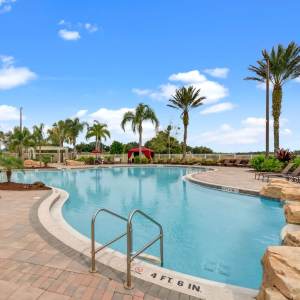 Community pool with lounge seating at Victoria Park Apartments in Davenport, Florida