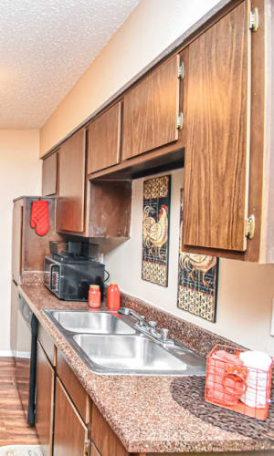 Kitchen with stainless-steel double sinks and black appliances at River Ranch in Sherman, Texas