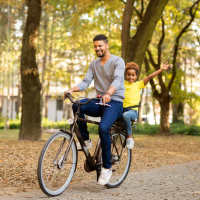 Resident with his kid cycling at Cloisters of Mount Holly in Mount Holly, North Carolina