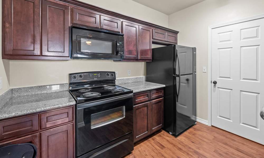 Modern kitchen with wooden cabinets at Las Torres Apartments in El Paso, Texas