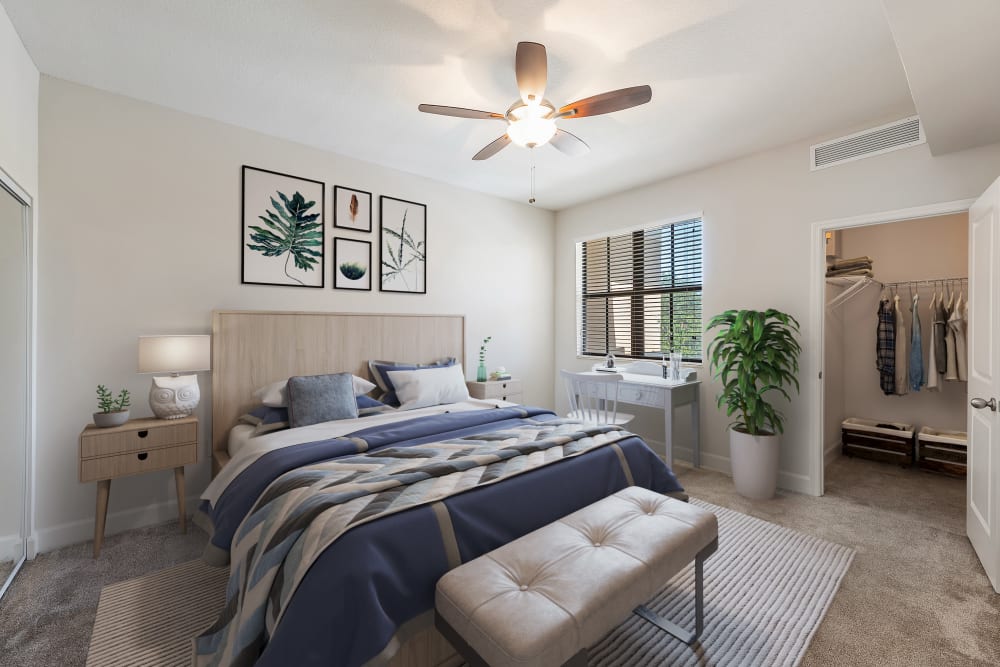 Spacious model bedroom with a desk by the window and a large walk-in closet at The Residences at Lakehouse in Miami Lakes, Florida