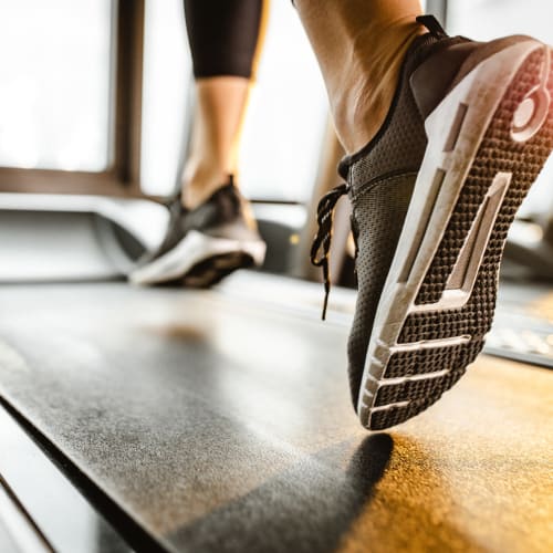 Resident working out on a treadmill in the fitness center at The Mallory in Raleigh, North Carolina