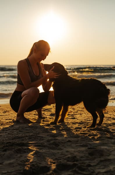 A woman on a beach with a dog near Westport Lofts in Belville, North Carolina