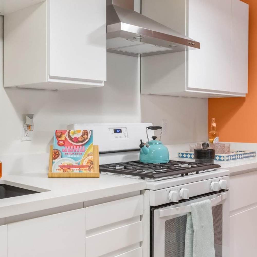 Modern kitchen with white cabinets and teal accents at Tempo Fremont in Fremont, California